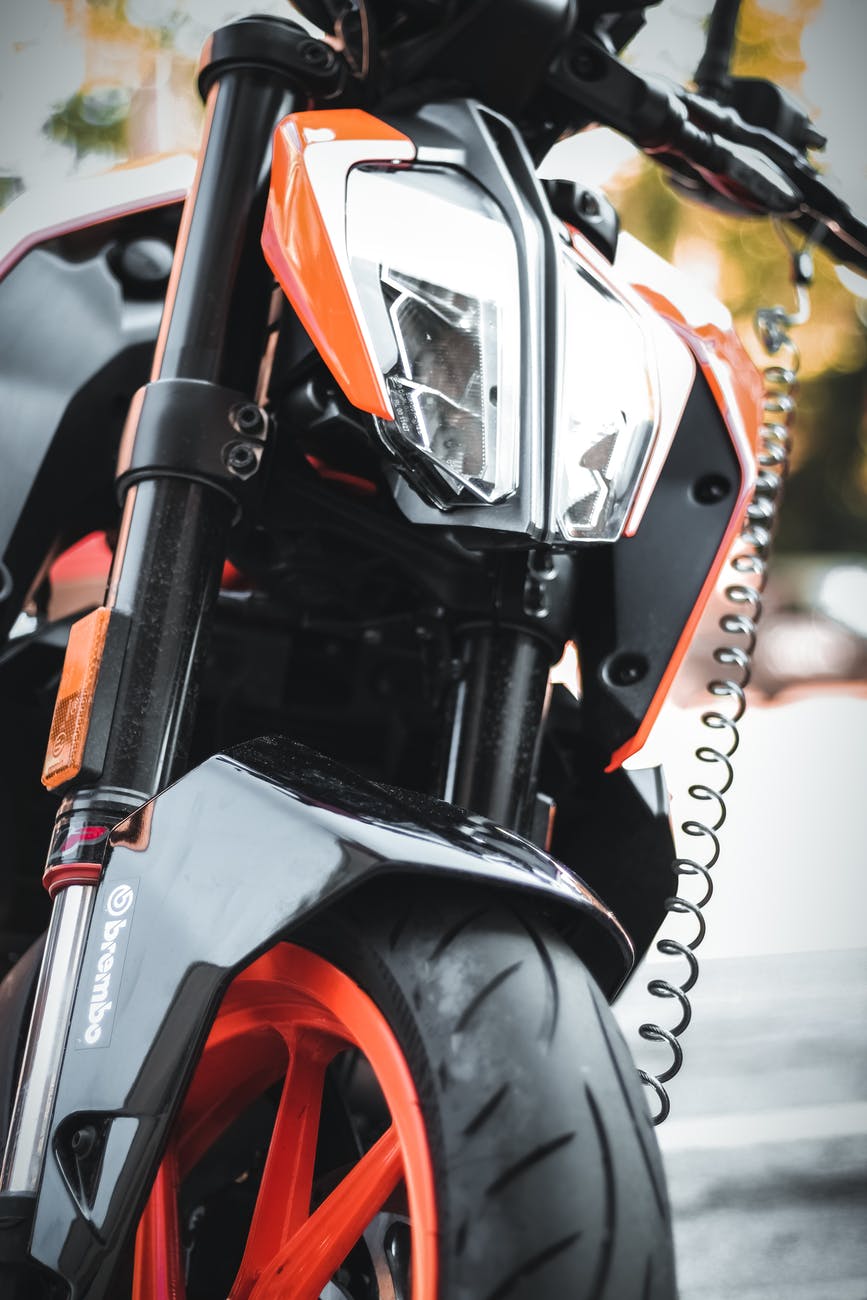 shallow focus photo of black and orange motorcycle