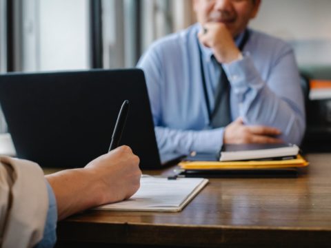 woman filling job application form in office with boss